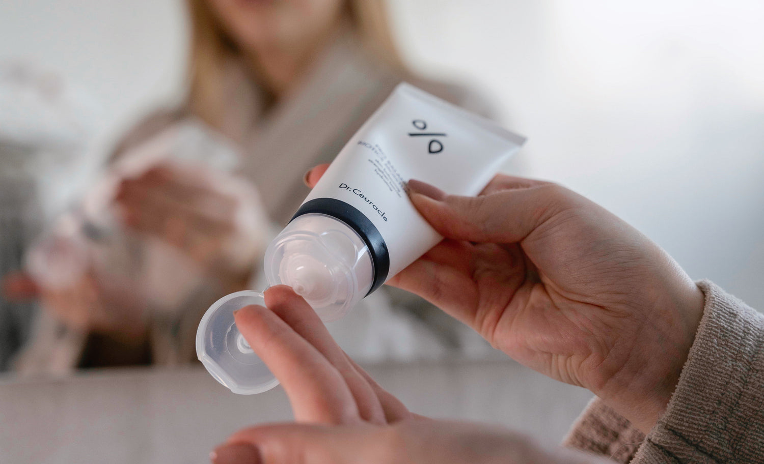 A girl holding a tube of Dr. Ceuracle Pro-Balance Biotics Moisturiser
